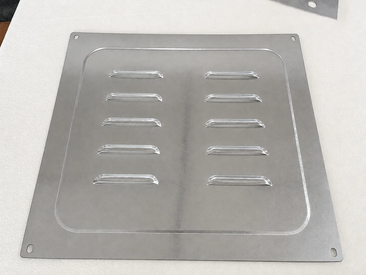 Louvered ventilation panel made by turret punching